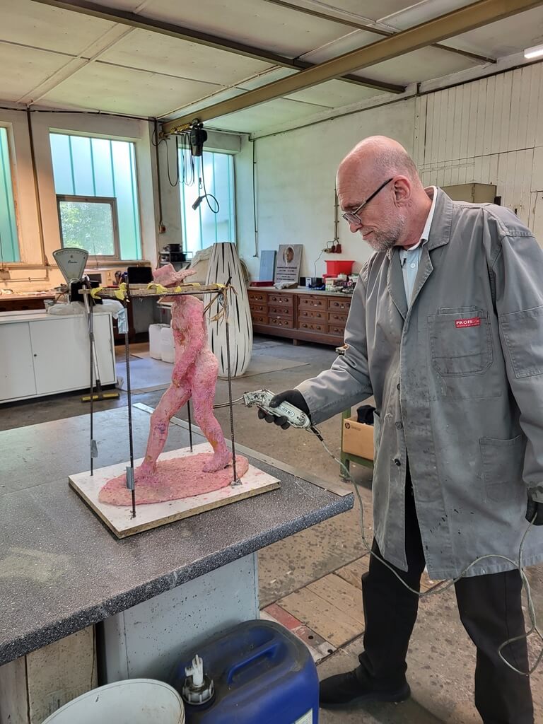 Wachsmodell Künstler vor Metallkunst